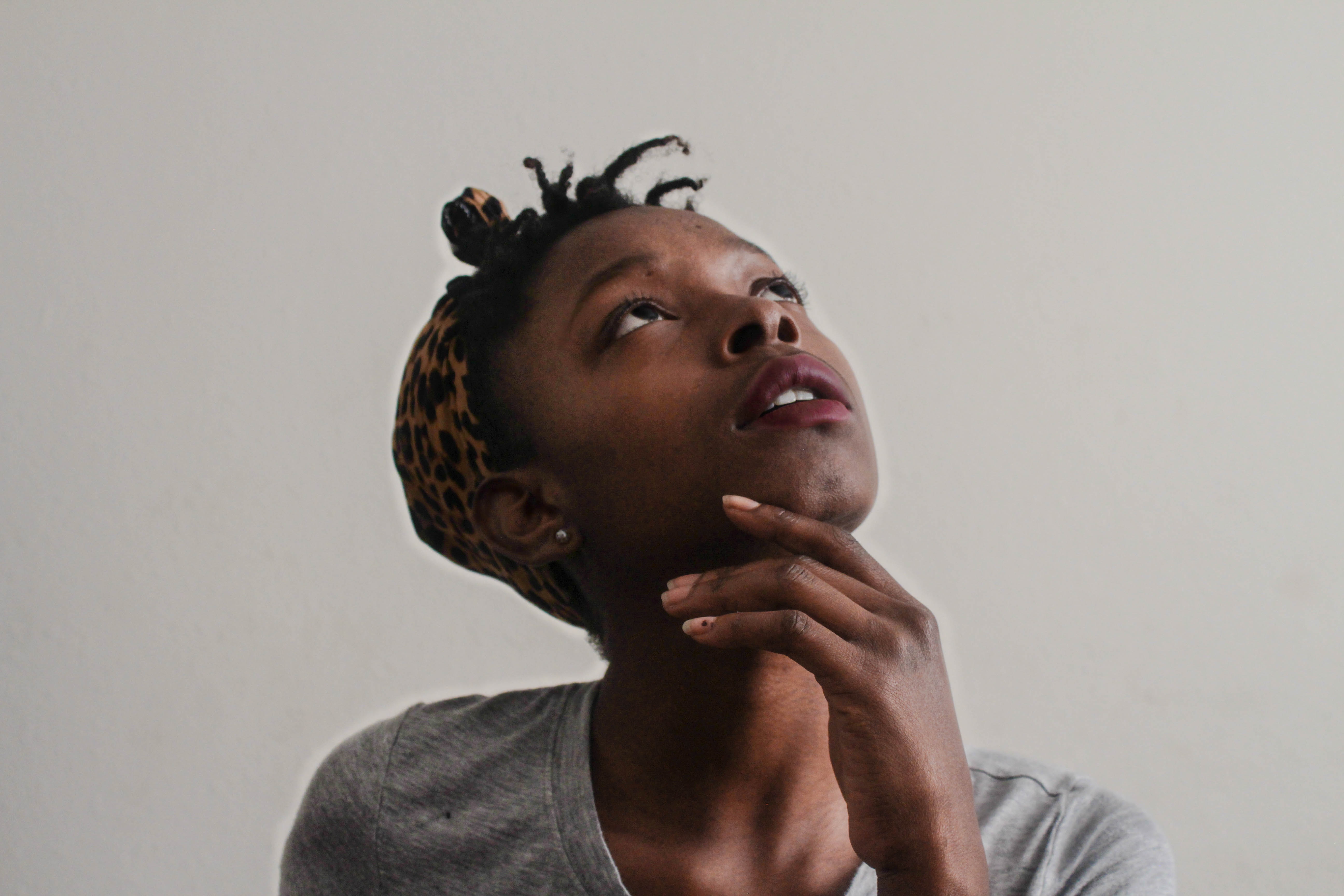 Black woman looking pensively up.