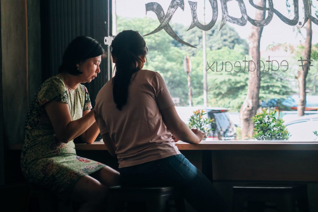 If you are near someone who has been affected by COVID-19 racism, you can ask them what kind of support they need. Women talking in a coffee shop.