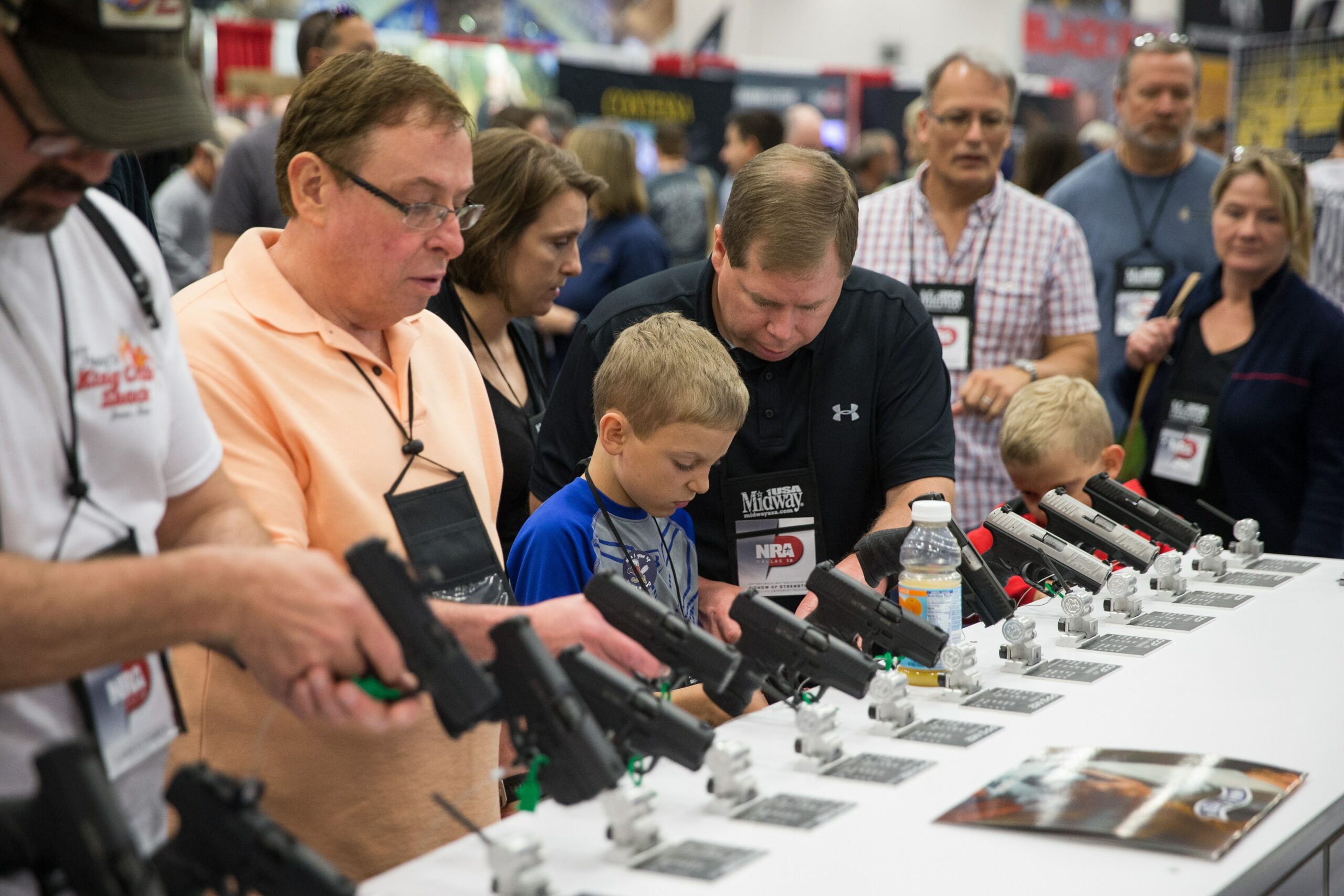 NRA conventiongoers, like these at the gun group’s 2018 big meeting, browse firearms exhibits.