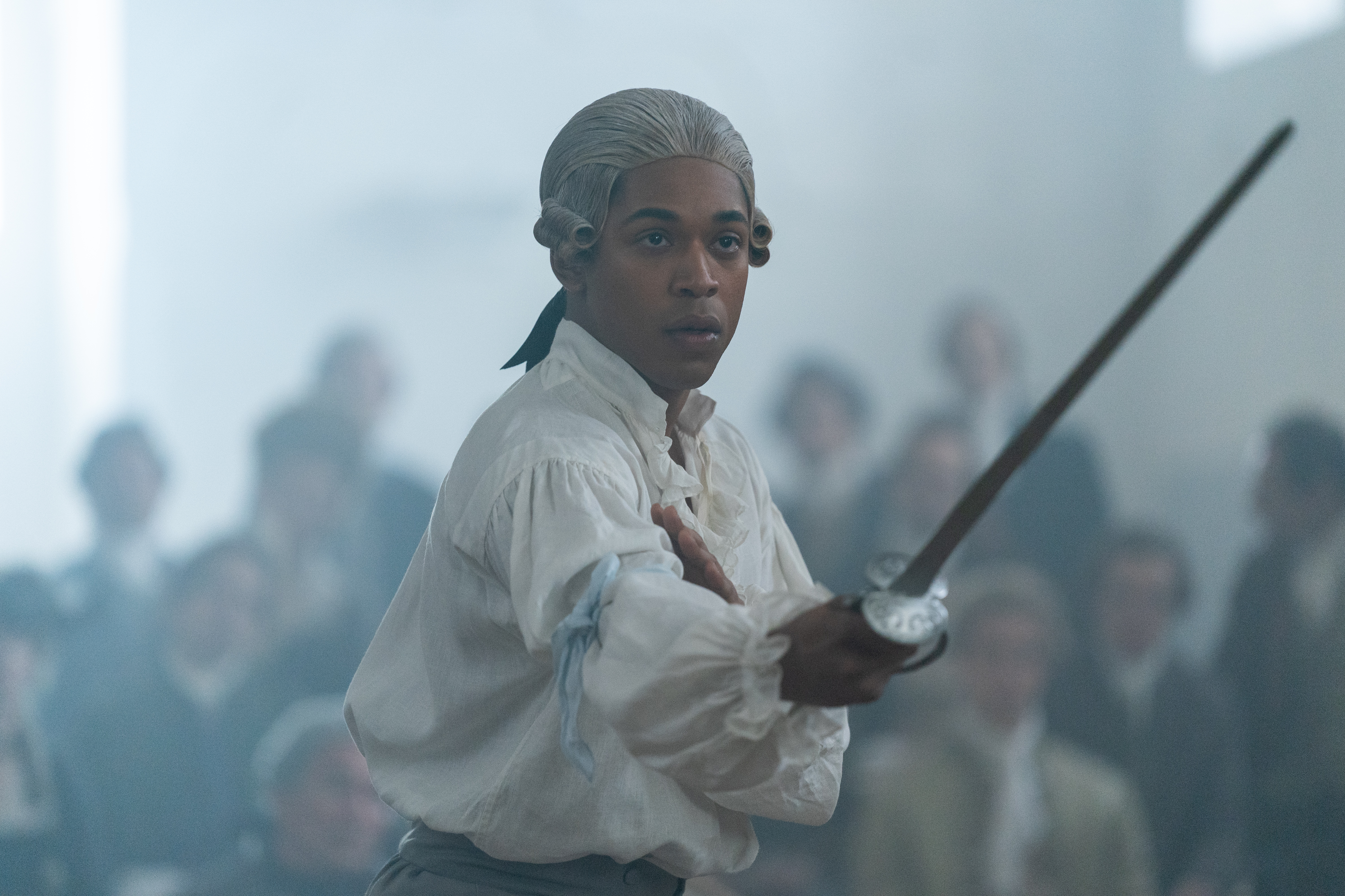 Kelvin Harrison Jr. in the film CHEVALIER, fencing in a crowd of people. Photo by Larry Horricks. Courtesy of Searchlight Pictures. © 2023 20th Century Studios All Rights Reserved.