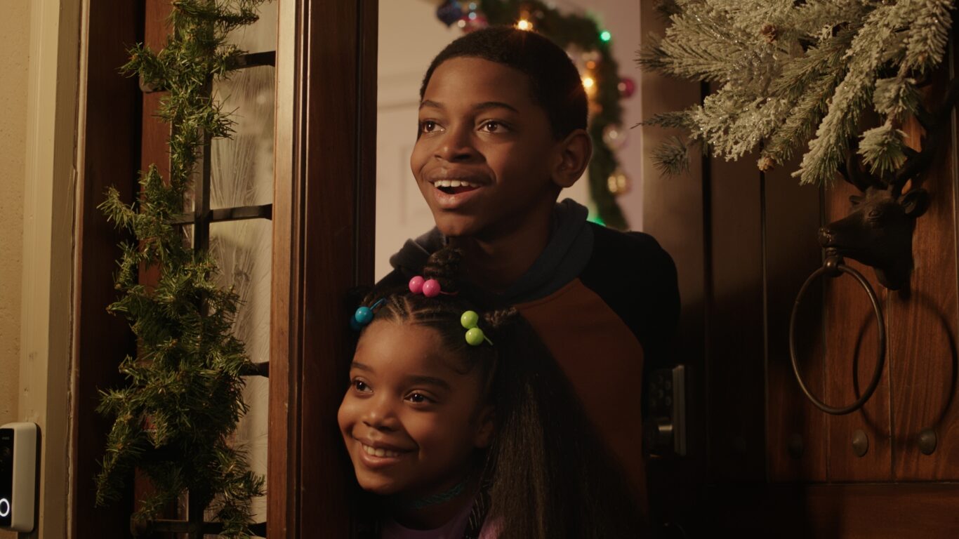 Charles Batson Jr. and Carlee Elston peek through a festive front door.