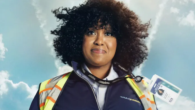 Natasha Rothwell smiling while wearing a TSA uniform.