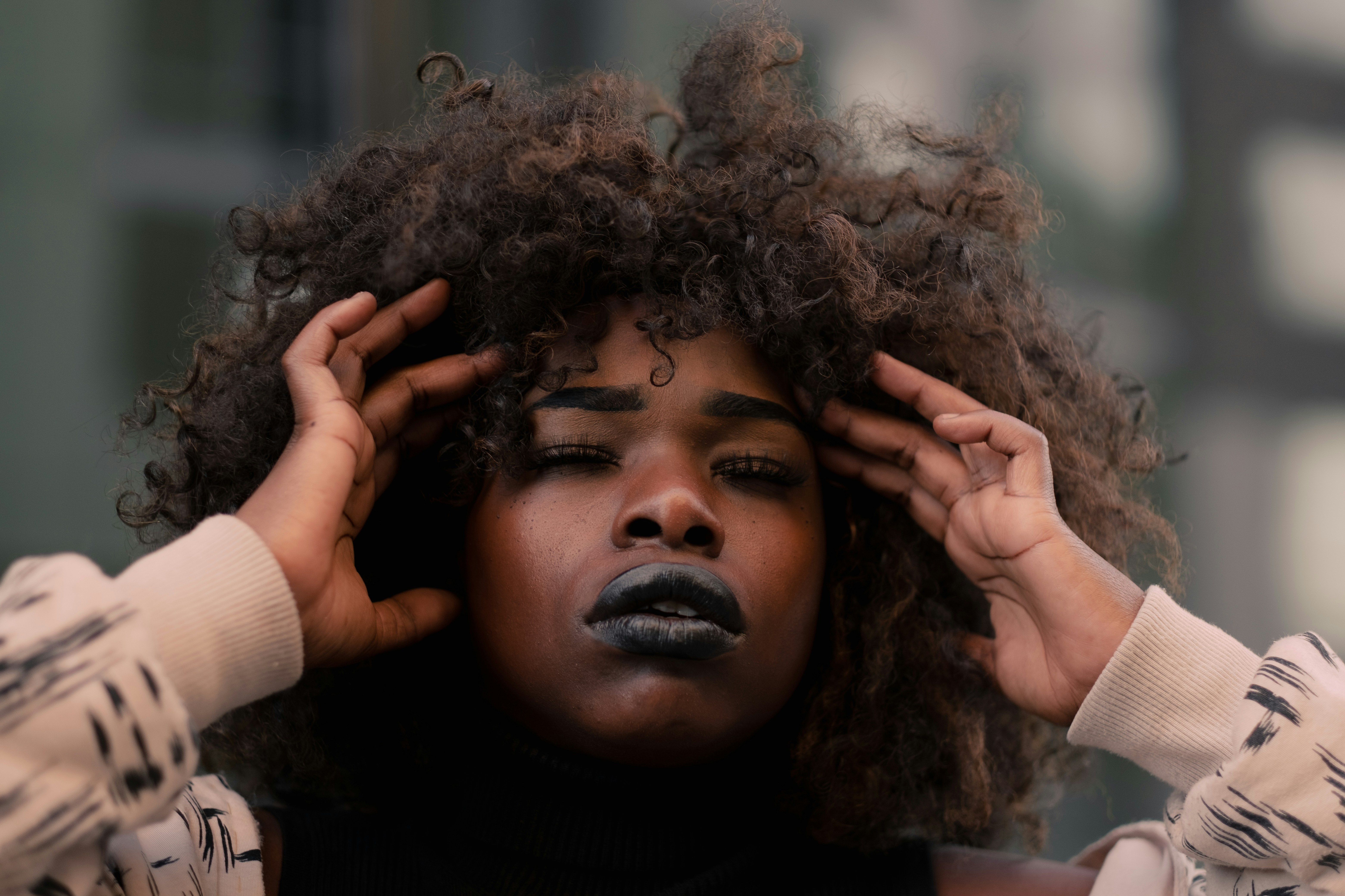 Black woman touching her temples in distress.