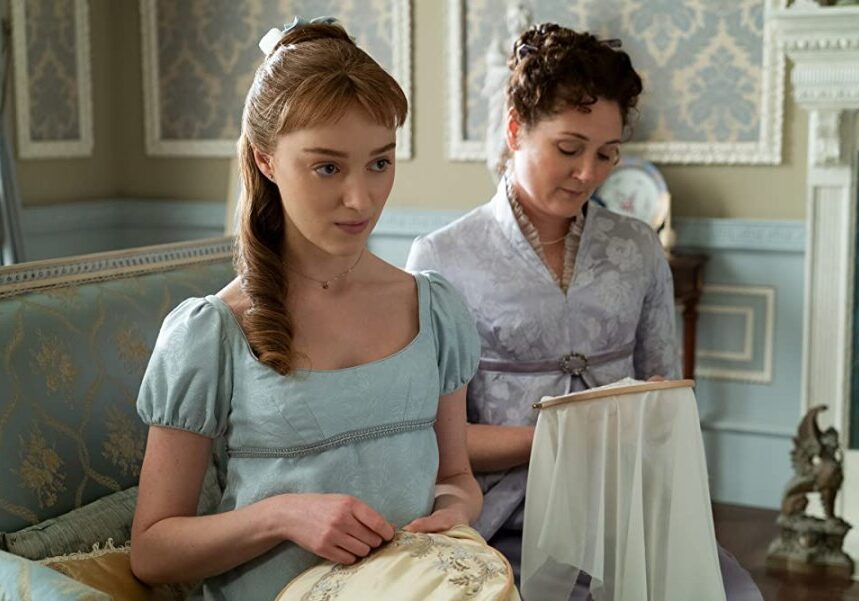 Daphne (Phoebe Dynevor) looking suspicious while she does needlework with her mother, Lady Violet Bridgerton (Ruth Gemmell). (Photo credit: Liam Daniel/Netflix)