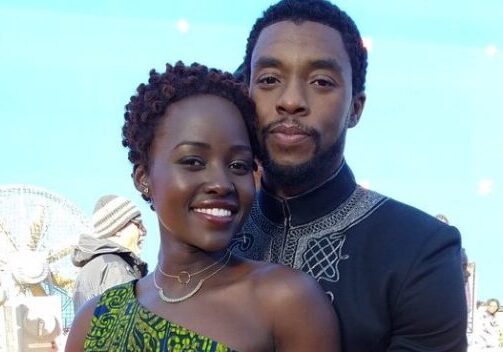 Lupita Nyong'o and Chadwick Boseman pose together in an embrace during a behind-the-scenes moment in Black Panther