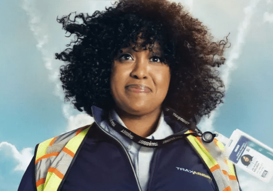 Natasha Rothwell smiling while wearing a TSA uniform.